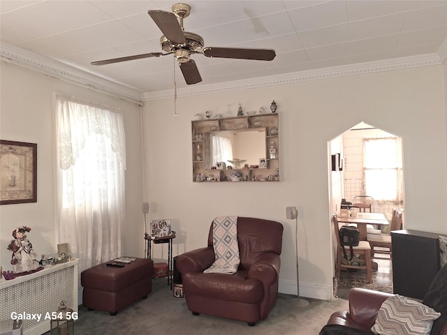 sitting room featuring crown molding, ceiling fan, and carpet