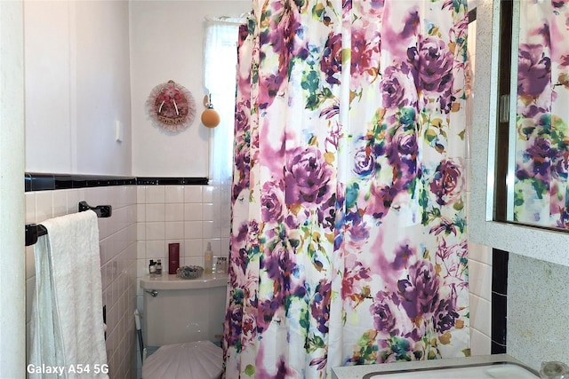 bathroom featuring tile walls, a shower with shower curtain, and toilet