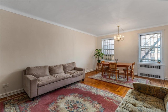 living room featuring crown molding, radiator heating unit, a chandelier, and parquet flooring