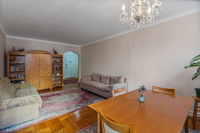 living room with an inviting chandelier, parquet flooring, and ornamental molding