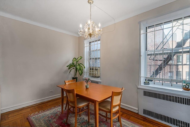 dining room featuring parquet floors, radiator heating unit, a chandelier, and plenty of natural light