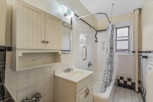 bathroom featuring tile patterned flooring, vanity, tile walls, and shower / bathtub combination with curtain