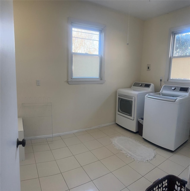 clothes washing area featuring washer and dryer and light tile patterned floors