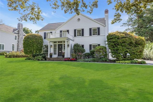 view of front of property with a balcony and a front yard