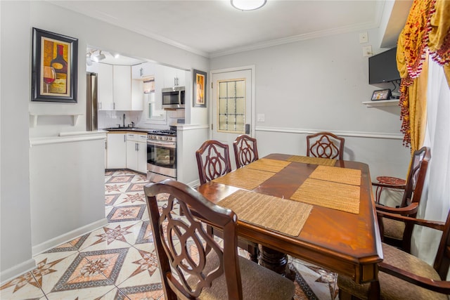 dining space with sink and crown molding