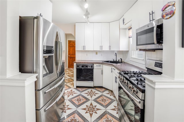 kitchen featuring stainless steel appliances, sink, white cabinets, and decorative backsplash