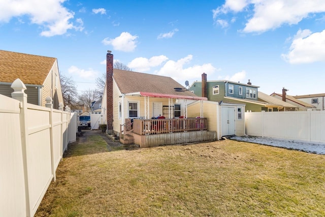 rear view of house featuring a yard and a deck