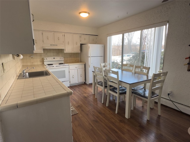 kitchen featuring tasteful backsplash, white appliances, dark hardwood / wood-style flooring, and sink