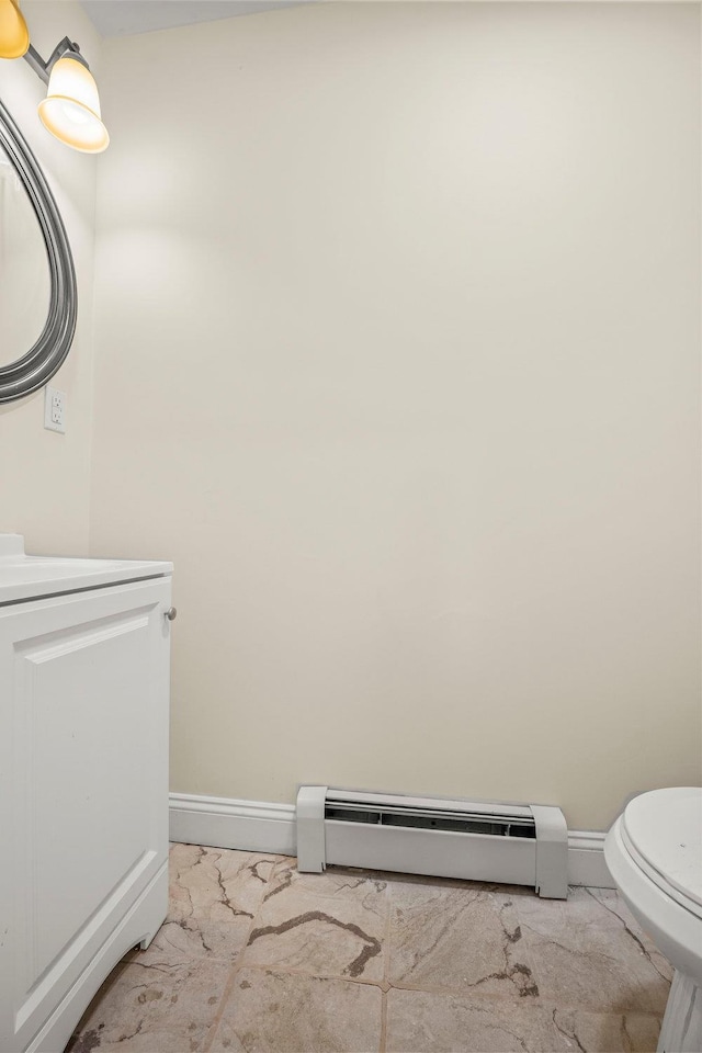 bathroom with vanity, toilet, and baseboard heating