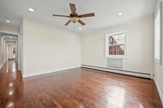 empty room with ceiling fan, a baseboard radiator, and dark hardwood / wood-style flooring