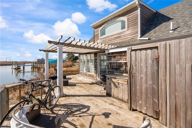 view of patio featuring a deck with water view and a pergola