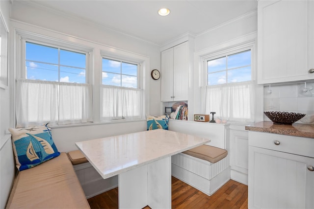 dining room with breakfast area, dark hardwood / wood-style flooring, crown molding, and a wealth of natural light