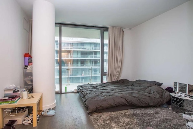 bedroom featuring expansive windows and wood-type flooring