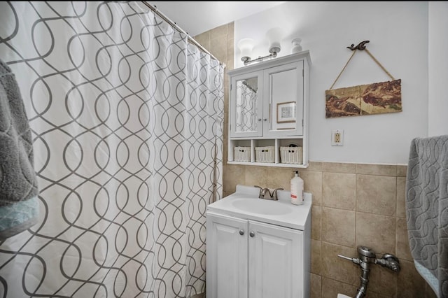 bathroom with vanity, curtained shower, and tile walls