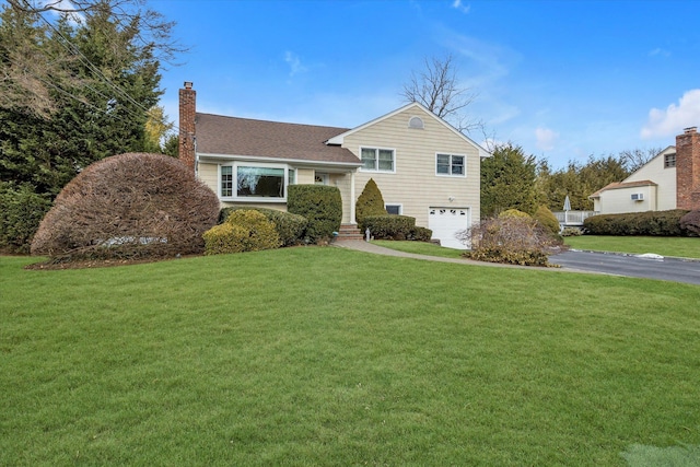 view of front of house featuring a garage and a front lawn