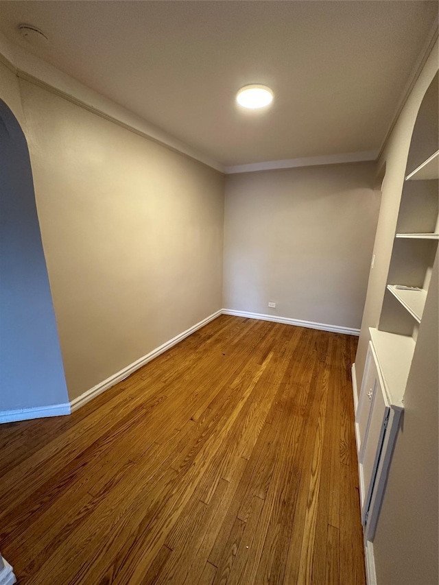 empty room with hardwood / wood-style floors and ornamental molding