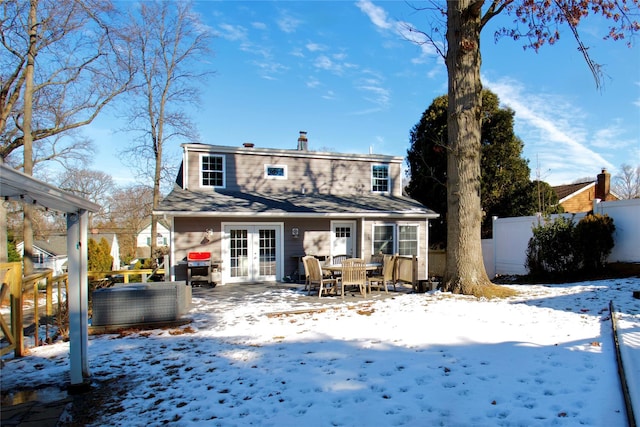 snow covered property with french doors