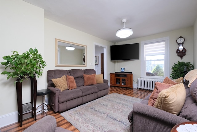 living room featuring radiator heating unit and dark hardwood / wood-style flooring