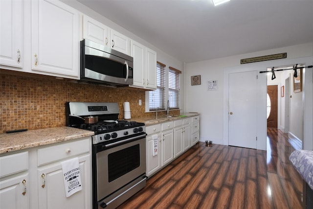 kitchen featuring dark hardwood / wood-style floors, tasteful backsplash, sink, white cabinets, and stainless steel appliances