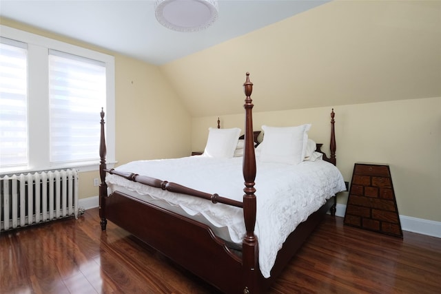 bedroom with radiator, vaulted ceiling, and dark hardwood / wood-style floors