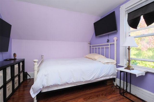 bedroom with vaulted ceiling and dark hardwood / wood-style floors