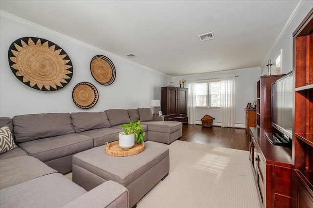 living room with hardwood / wood-style flooring, crown molding, and a baseboard heating unit