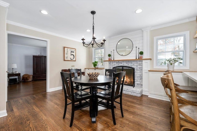 dining room with a fireplace, ornamental molding, dark hardwood / wood-style floors, and a healthy amount of sunlight