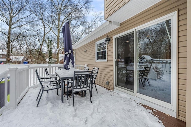 snow covered patio with a wooden deck