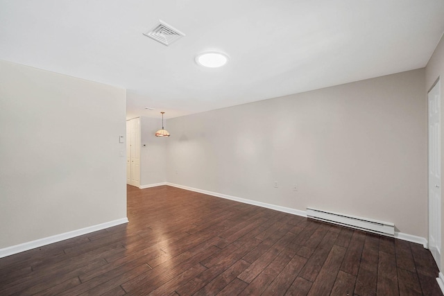 spare room with a baseboard radiator and dark hardwood / wood-style floors