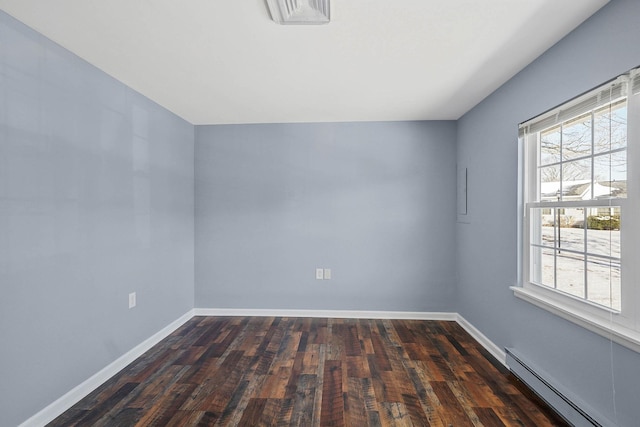 empty room featuring dark wood-type flooring, a wealth of natural light, and baseboard heating