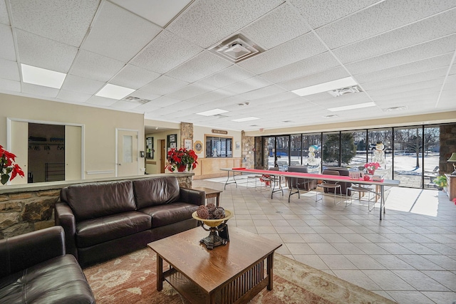 living room featuring a paneled ceiling and tile patterned floors