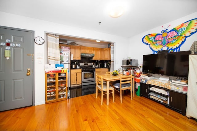 kitchen featuring tasteful backsplash, appliances with stainless steel finishes, light brown cabinetry, and light hardwood / wood-style flooring