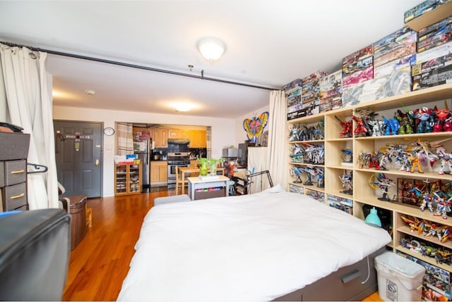 bedroom featuring dark hardwood / wood-style floors and stainless steel refrigerator