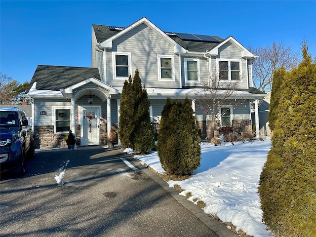 view of front facade featuring solar panels and a porch