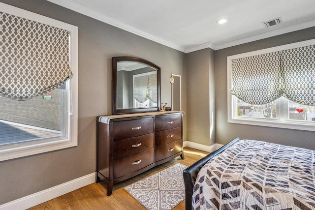 bedroom with crown molding and light wood-type flooring