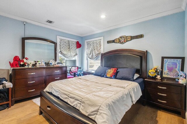 bedroom with crown molding and light wood-type flooring