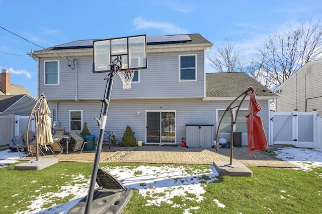 rear view of house featuring a yard, a patio area, and solar panels