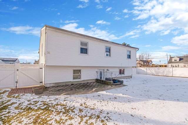 view of snow covered back of property