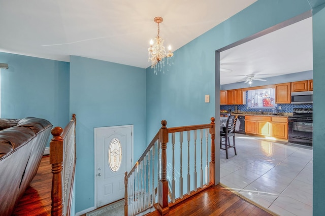 tiled foyer entrance with an inviting chandelier