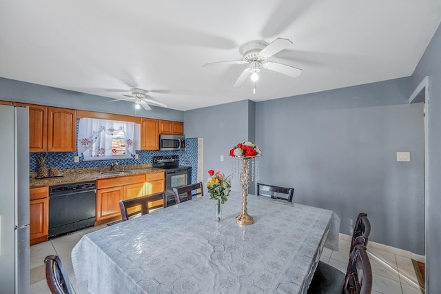 tiled dining space featuring ceiling fan and sink