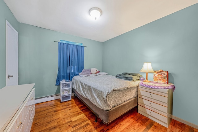 bedroom featuring a baseboard radiator and hardwood / wood-style floors