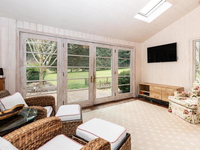 sunroom / solarium featuring vaulted ceiling with skylight