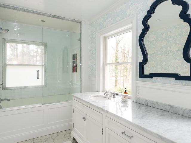 bathroom with vanity, plenty of natural light, and shower / bath combination with glass door