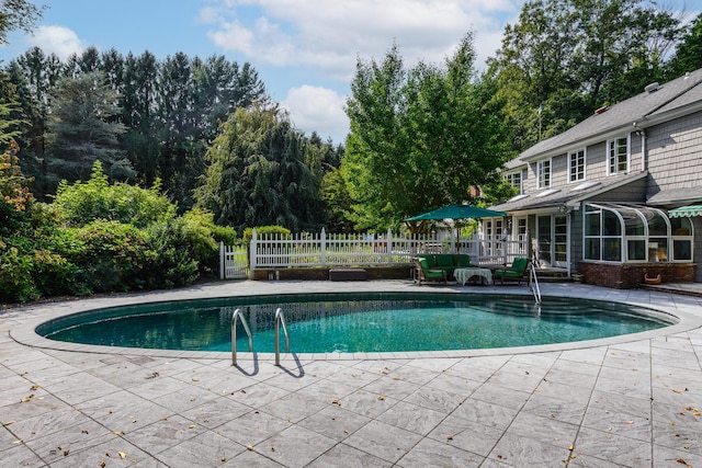 view of pool with a patio area and a sunroom