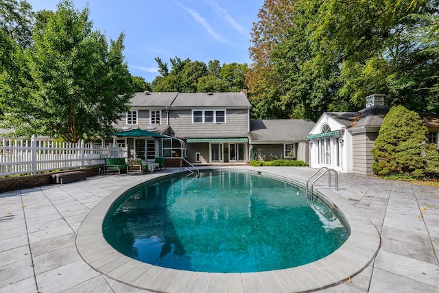 view of swimming pool with an outbuilding and a patio