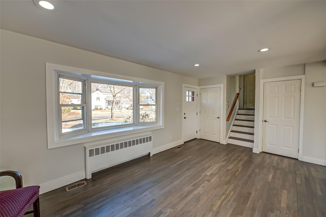 foyer featuring dark wood-type flooring and radiator heating unit