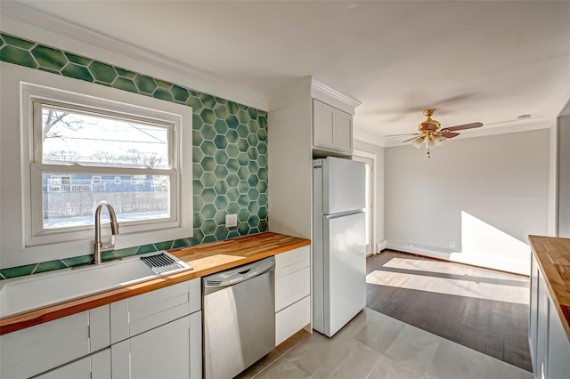 kitchen featuring white cabinetry, stainless steel dishwasher, butcher block counters, and white fridge