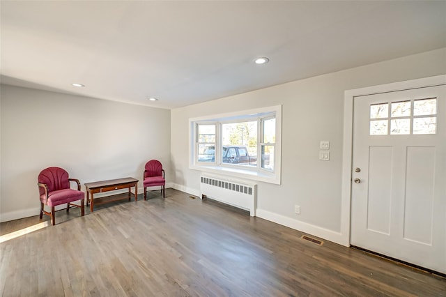 foyer with wood-type flooring and radiator heating unit