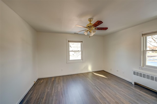 unfurnished room featuring hardwood / wood-style floors, radiator heating unit, and ceiling fan