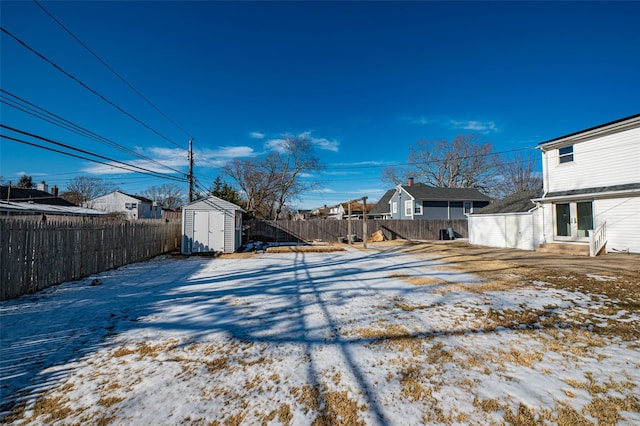 yard covered in snow with a storage shed